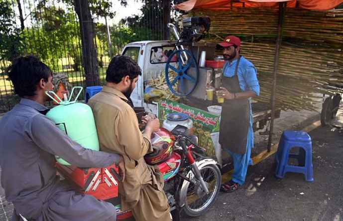 Vendor Serves Sugarcane Juice During City Heatwave