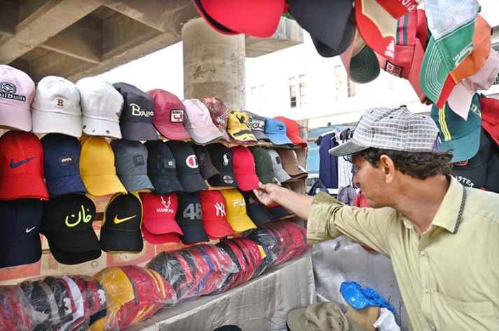 Street Vendor Displays Colorful Caps at Railway Chowk to Attract Customers in the City Center