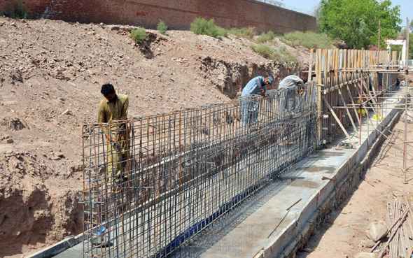 Workers Busy Fixing Iron Rods at Construction Drainage Site